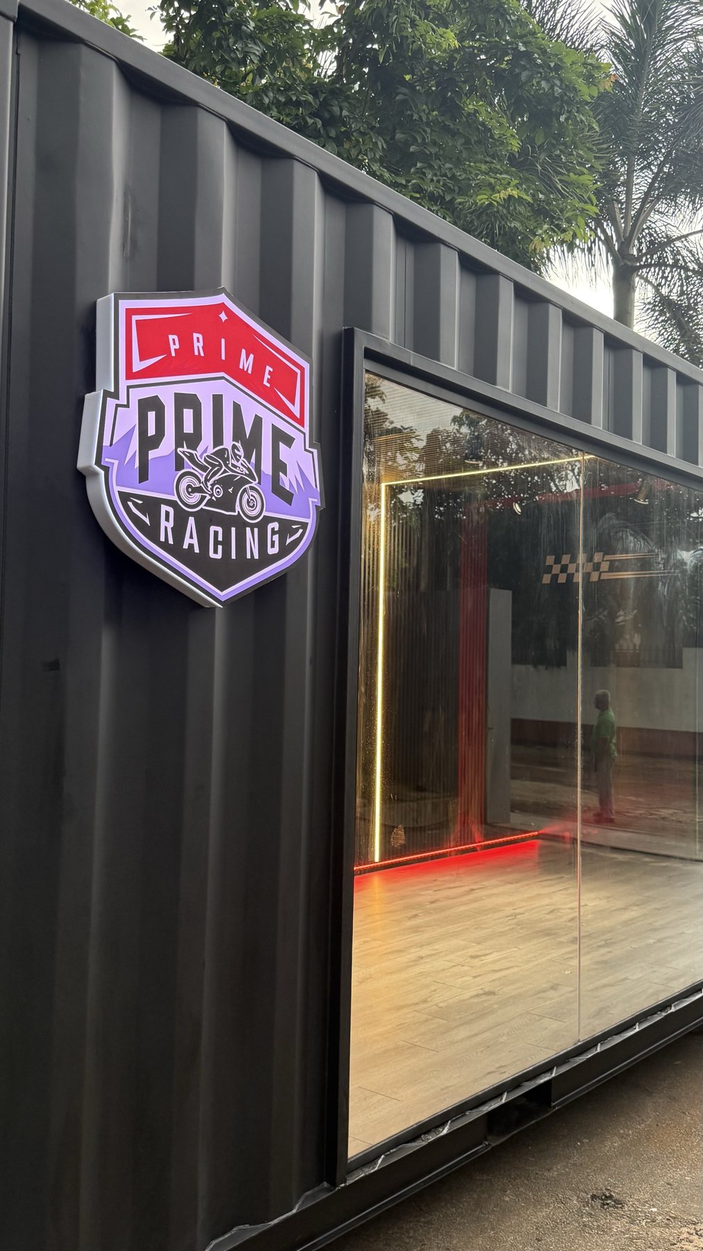 Prime Racing showroom entrance with the shield logo on black container steel